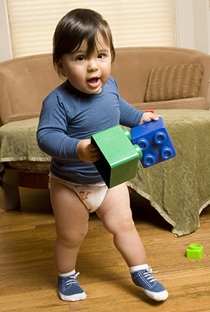 Niño pequeño que camina con juguetes.