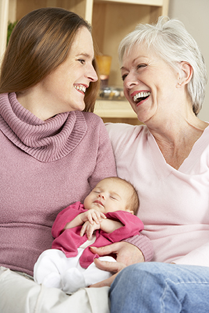 Madre reciente y abuela sosteniendo a su nueva nieta. 