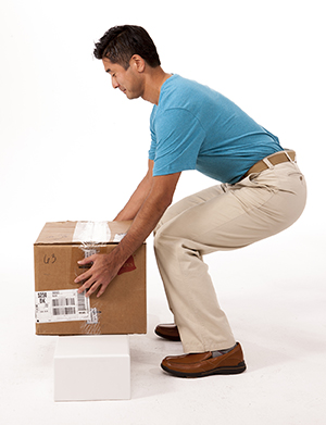 Hombre levantando una caja de manera segura.