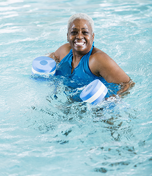 Mujer que ejercita en la piscina.